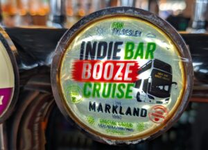 Close-up of a beer tap handle at The Markland featuring a custom badge for the Indie Bar Booze Cruise.